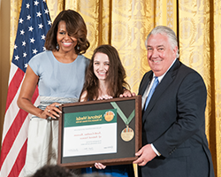 Museum Director Emlyn Koster and a Museum volunteer accept the National Medal for Museum and Library Service on behalf of the Museum from First Lady Michelle Obama.